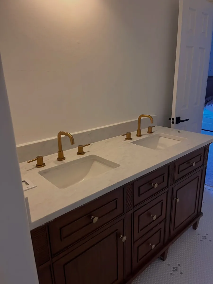 Completed bathroom with double vanity, marble-look countertop and brushed gold fixtures